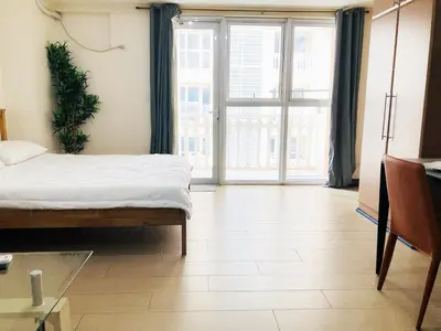 a bedroom with a bed and a large window at Grand view Venice 1BR with balcony near BGC in Manila