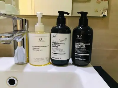 three bottles ofodorizers sitting on a bathroom sink at Grand view Venice 1BR with balcony near BGC in Manila