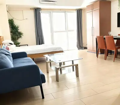 a living room with a couch and a table at Grand view Venice 1BR with balcony near BGC in Manila