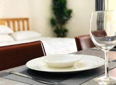 a table with a plate and a glass of wine at Grand view Venice 1BR with balcony near BGC in Manila