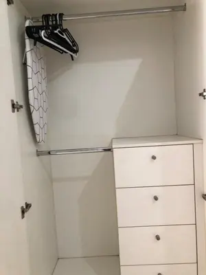 a walk in closet with a refrigerator and shoes at Haven in Manila Venice 1BR with balcony near BGC in Manila