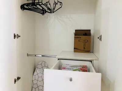 a white closet with a box and a drawer at Haven in Manila Venice 1BR with balcony near BGC in Manila