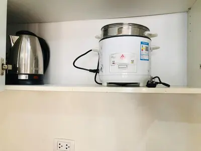 a slow cooker sitting on a shelf in a kitchen at Haven in Manila Venice 1BR with balcony near BGC in Manila