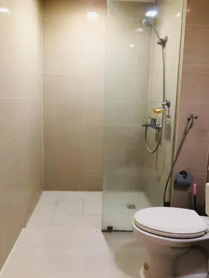 a bathroom with a toilet and a shower at Haven in Manila Venice 1BR with balcony near BGC in Manila
