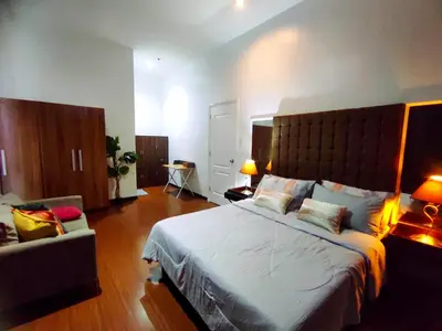 a bedroom with a large bed and a couch at Big NEW 1 Bedroom corner unit with Balconies - FREE Sauna Pool Gym View of Skyline, Manila Bay, Sunset in Manila
