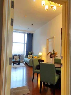 a living room with a couch and a table and chairs at Big NEW 1 Bedroom corner unit with Balconies - FREE Sauna Pool Gym View of Skyline, Manila Bay, Sunset in Manila