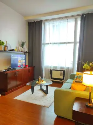 a living room with a couch and a table at Big NEW 1 Bedroom corner unit with Balconies - FREE Sauna Pool Gym View of Skyline, Manila Bay, Sunset in Manila