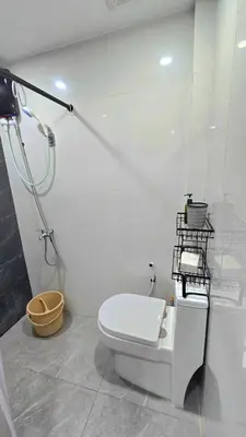 a white bathroom with a toilet and a shower at Studio Units near Airport by Jade Studio Apartments in Manila