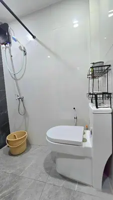 a bathroom with a white toilet and a shower at Studio Units near Airport by Jade Studio Apartments in Manila