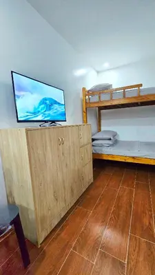 a bedroom with bunk beds and a flat screen tv at Studio Units near Airport by Jade Studio Apartments in Manila