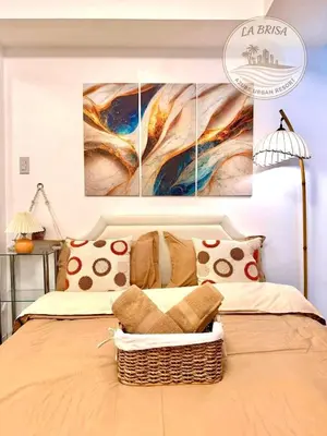 a bedroom with a bed with two paintings on the wall at Staycation at CJS in Manila
