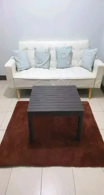 a living room with a white couch and a coffee table at Staycation at CJS in Manila