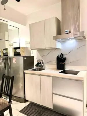 a kitchen with white cabinets and a stainless steel refrigerator at Staycation at CJS in Manila