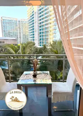 a balcony with a table and chairs and palm trees at Staycation at CJS in Manila