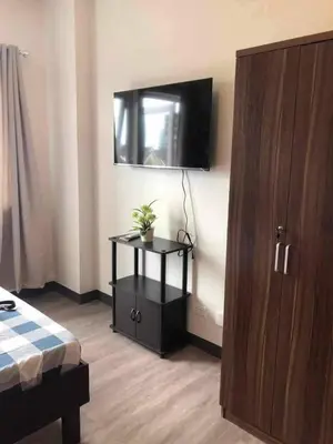 a room with a bed and a tv and a cabinet at Staycation at CJS in Manila