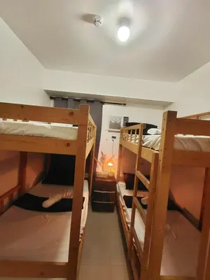 a room with three bunk beds in a room at Bahay Pahuway in Manila