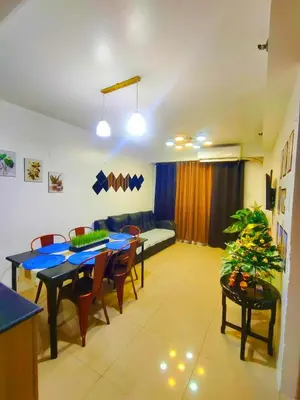 a living room with a table and chairs and a couch at Bahay Pahuway in Manila