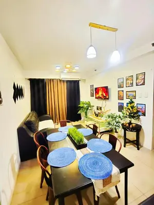 a living room with a table and chairs and a living room at Bahay Pahuway in Manila