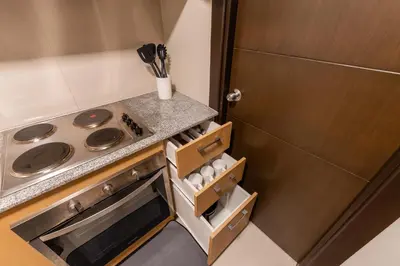 a small kitchen with a stove and a refrigerator at Spacious 3 BR in Uptown Parksuites, BGC Fast Wi Fi Washer in Manila