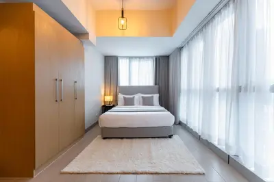 a bedroom with a bed and a large window at Spacious 3 BR in Uptown Parksuites, BGC Fast Wi Fi Washer in Manila