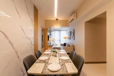 a dining room with a long table and chairs at Spacious 3 BR in Uptown Parksuites, BGC Fast Wi Fi Washer in Manila