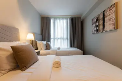 a hotel room with two beds and a window at Spacious 3 BR in Uptown Parksuites, BGC Fast Wi Fi Washer in Manila