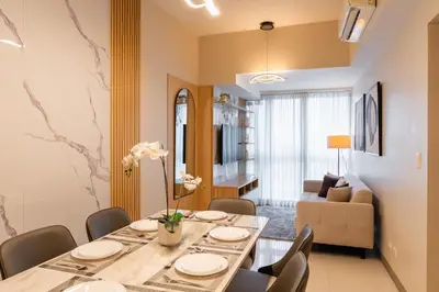 a dining room with a table and chairs and a couch at Spacious 3 BR in Uptown Parksuites, BGC Fast Wi Fi Washer in Manila