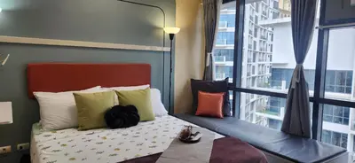 a bedroom with a bed with pillows and a window at 22e BGC Unit 3 mins Walk to The Venice Grand Canal Mall Pet Friendly in Manila