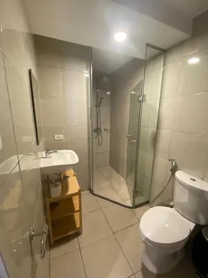 a bathroom with a shower and a toilet and a sink at EDSA Heights Penthouse unit 3402 AMA Tower Residences in Manila