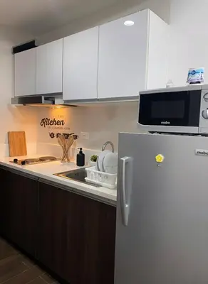 a kitchen with a refrigerator and a microwave at Air Residences 46F Stunning View Wifi & Netflix in Manila