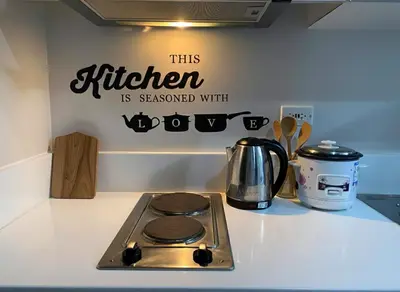 a kitchen stove with a sign on the wall at Air Residences 46F Stunning View Wifi & Netflix in Manila