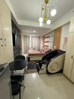 a bedroom with a bed and a table and chairs at Staycation By ABBYBI in Manila