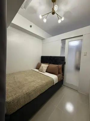 a bedroom with a bed and a ceiling at Staycation By ABBYBI in Manila