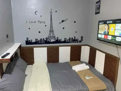 a bedroom with a bed with a mural of the eiffel tower at Airport Transient Pasay in Manila