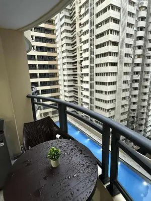 a table with a plant on a balcony with buildings at Sy bay suites beside okada manila near MOA COD T3 MSV2117H in Manila