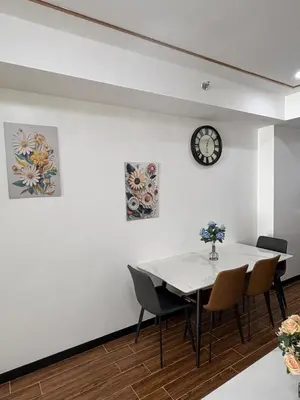 a dining room with a table and chairs and a clock at Sy bay suites beside okada manila near MOA COD T3 MSV2117H in Manila