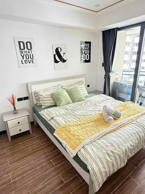 a bedroom with a large bed with green pillows at Sy bay suites beside okada manila near MOA COD T3 MSV2117H in Manila