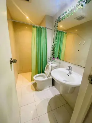 a bathroom with a toilet and a sink at Azure Urban Staycation in Manila