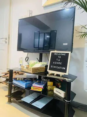 a tv sitting on top of a shelf with books at Azure Urban Staycation in Manila