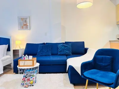 a blue couch and two chairs in a living room at The Serene Studio by Kozy Mood in Manila