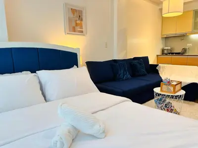 a living room with two beds and a couch at The Serene Studio by Kozy Mood in Manila