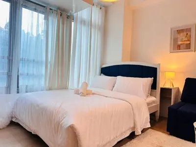 a bedroom with a large bed with a teddy bear on it at The Serene Studio by Kozy Mood in Manila