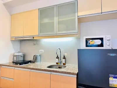 a kitchen with a sink and a microwave at The Serene Studio by Kozy Mood in Manila