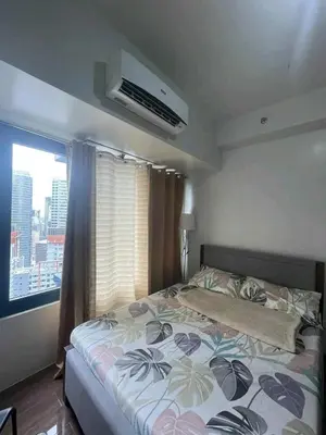 a bedroom with a bed and a window at Air residence city view staycation in Manila
