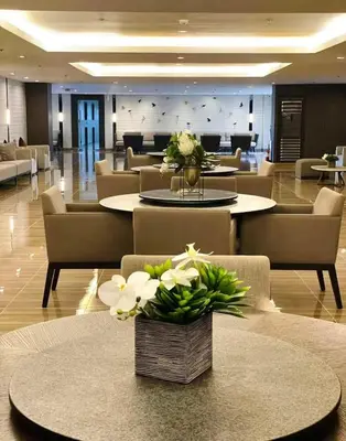 a lobby with tables and couches with flowers on them at Air residence city view staycation in Manila