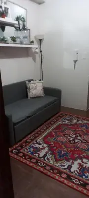a couch in a living room with a rug at Air residence city view staycation in Manila