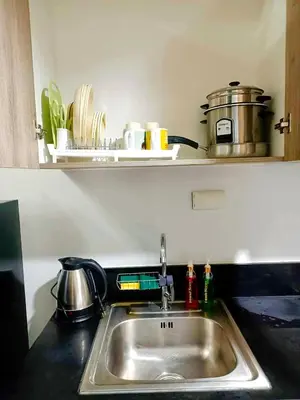 a kitchen sink with a pot on a shelf above it at Seren View Bedspace - S Residences in Manila