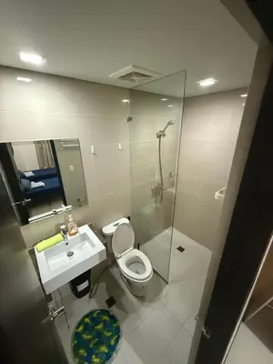 a bathroom with a toilet and a sink and a shower at 101 Newport Boulevard Pasay City Condotel in Manila