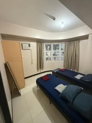a room with two beds and a window at 101 Newport Boulevard Pasay City Condotel in Manila