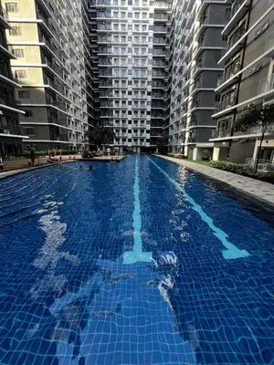 a large blue swimming pool with tall buildings at MOA GRAND STAY Suite08 Newly Turn-over Only! in Manila